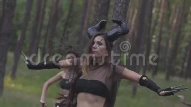 穿着森林居民或魔鬼的戏剧服装的年轻妇女在迷人的森林中表现出芬芳或进行仪式